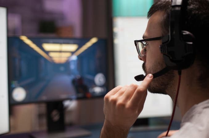 Man wearing eyeglasses and a headset while playing a video game