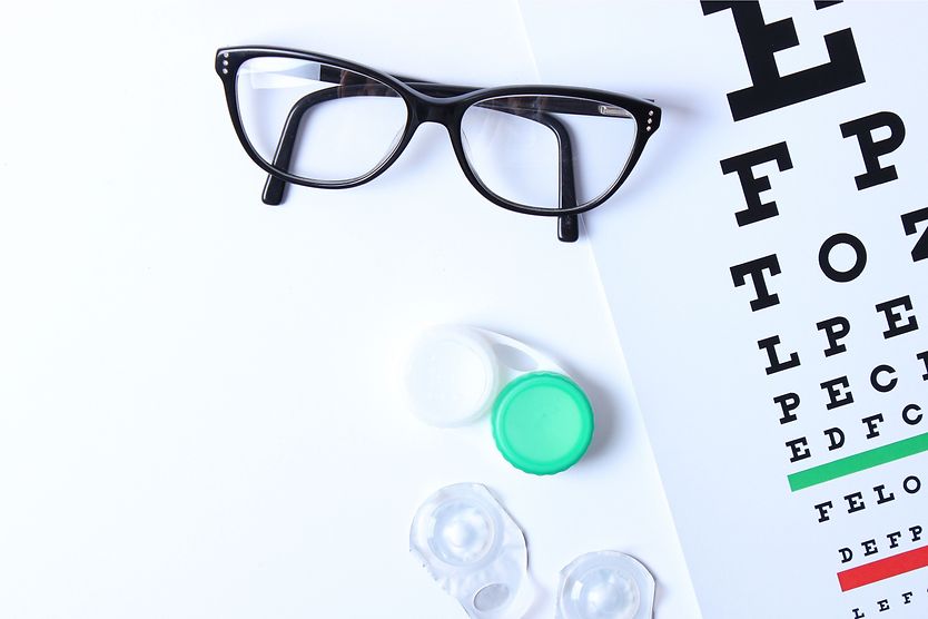 Contacts and eyeglasses on an eye chart