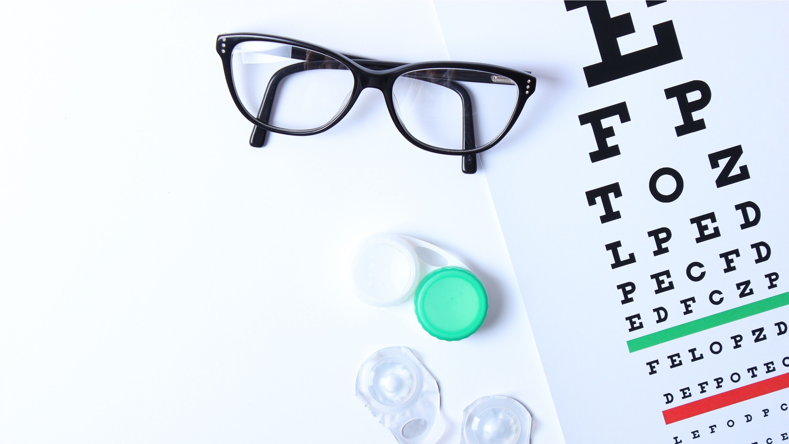 Contacts and eyeglasses on an eye chart