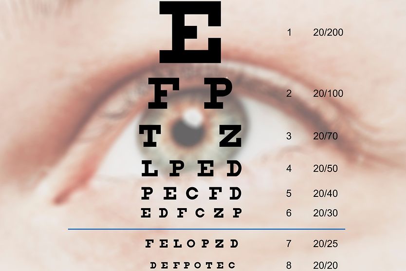 woman holding up a Snellen eye chart