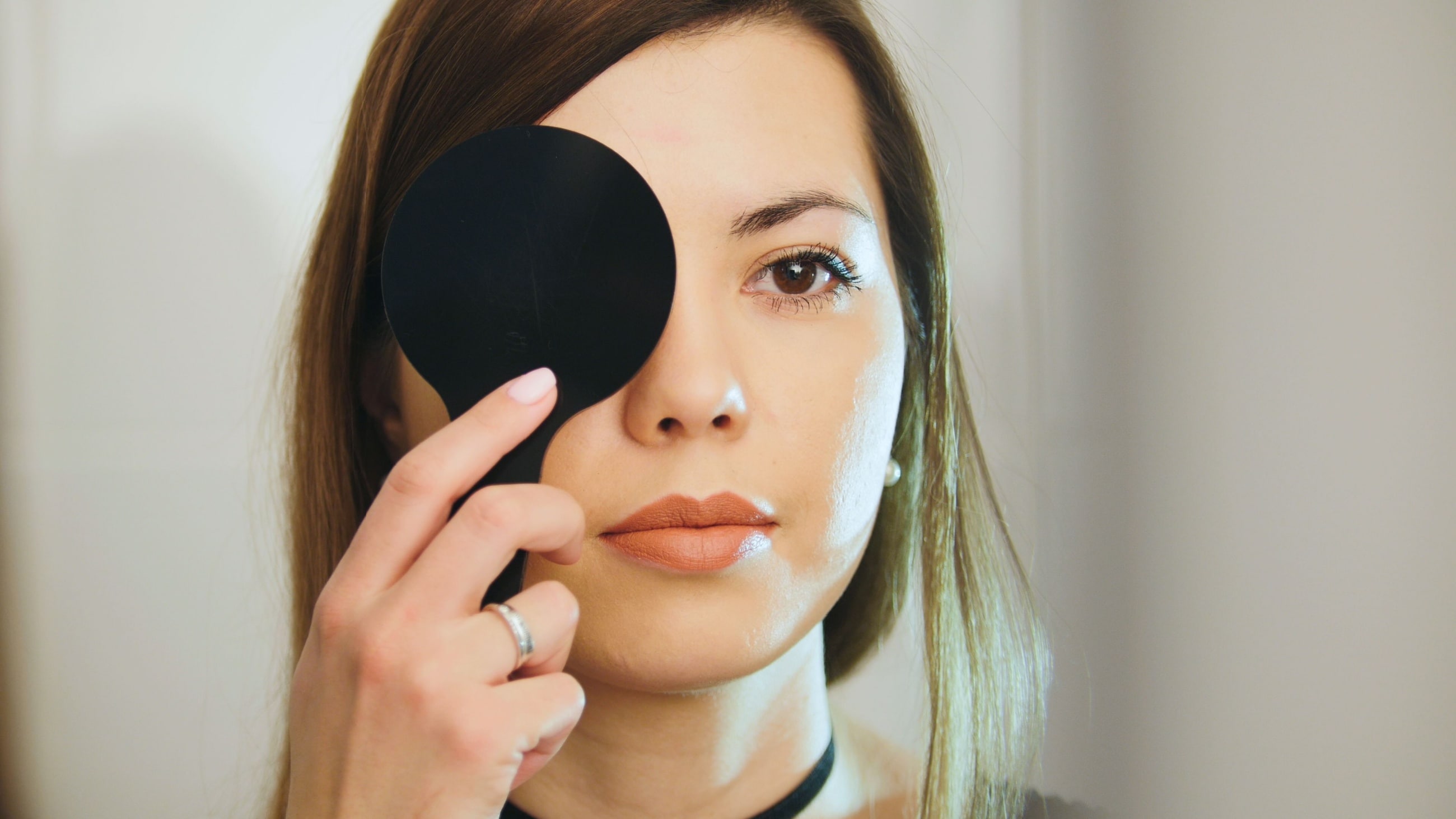 woman covering her eye during eye test