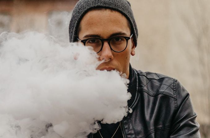 man wearing eyeglasses and vaping