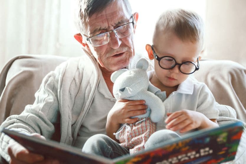 grandfather reading a book to his grandson grandfather reading a book to his grandson