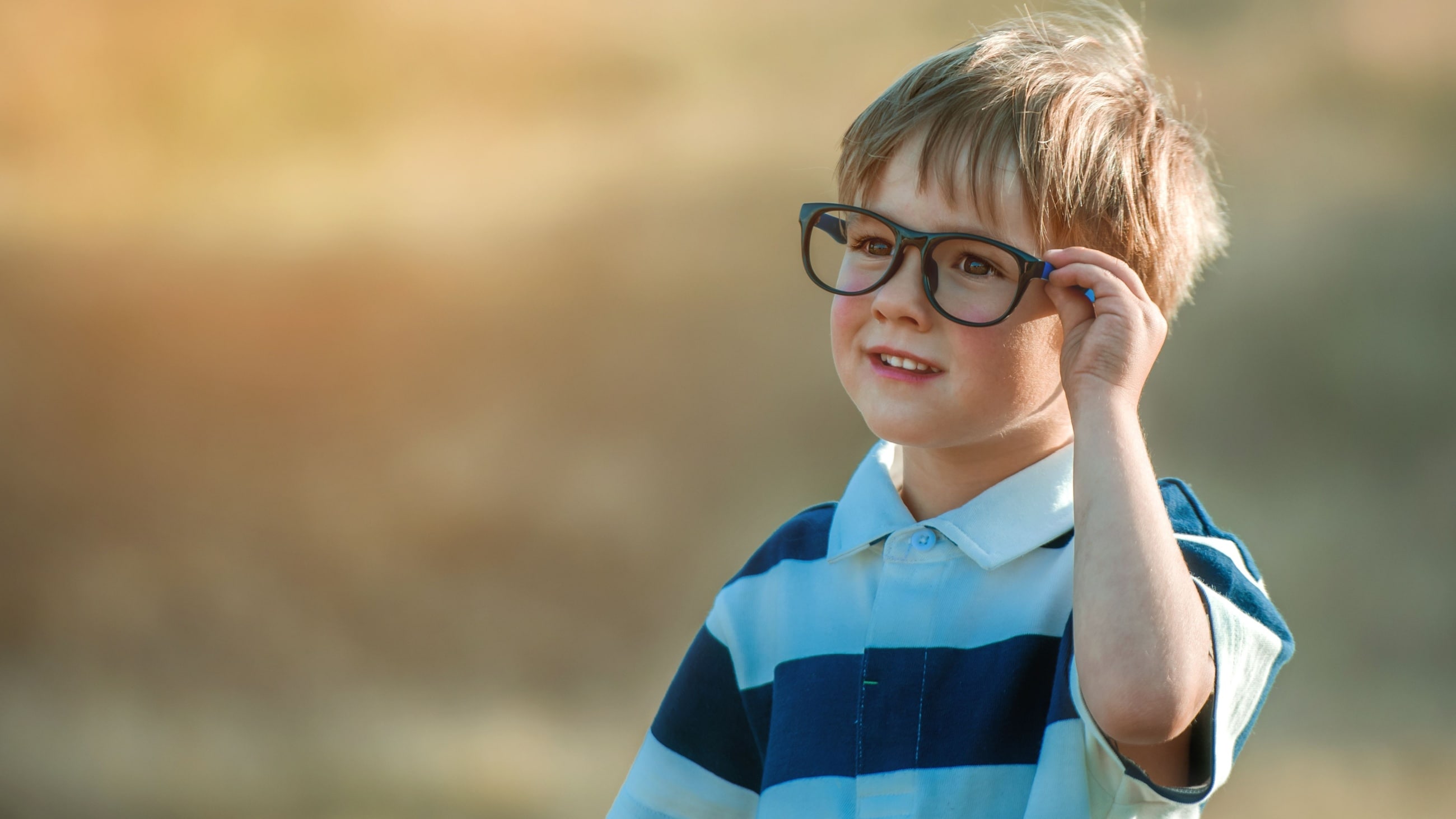 boy wearing glasses outside in sunshine boy wearing glasses outside in sunshine