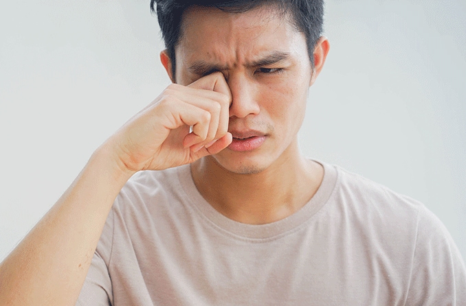 man rubbing eye due to giant papillary conjunctivitis