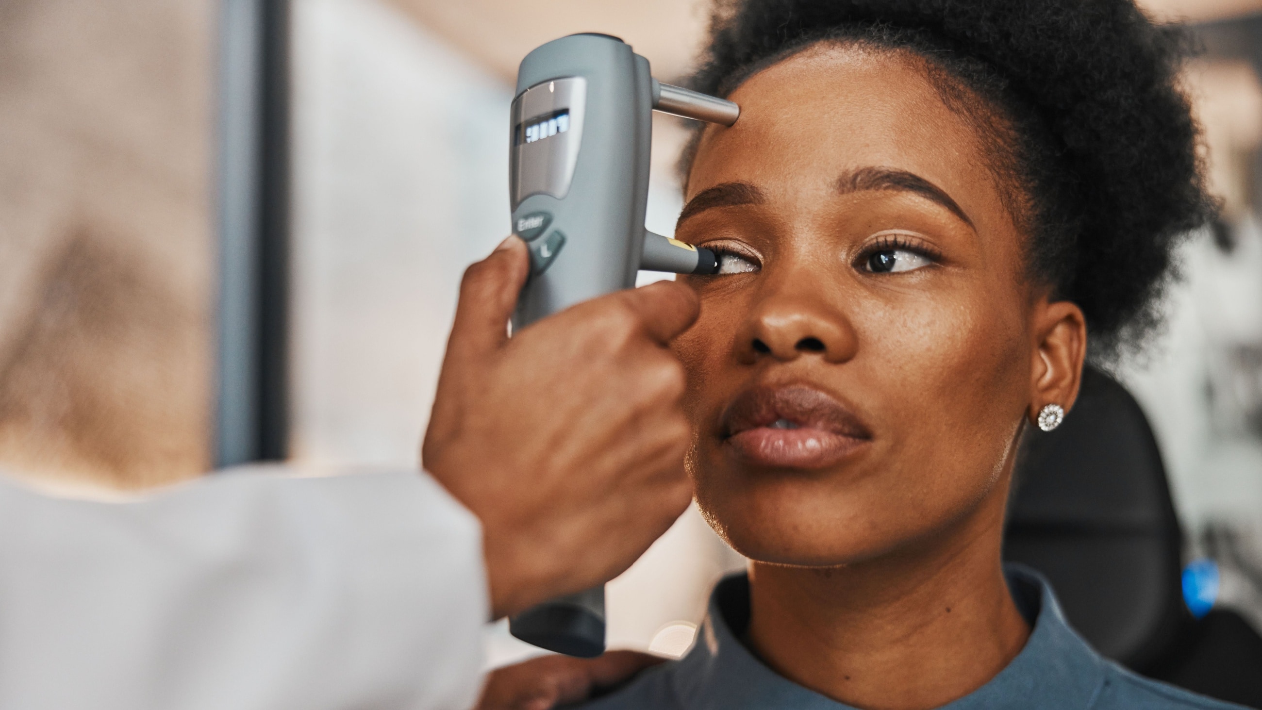 Eye doctor testing patient's eyes with tonometer Eye doctor testing patient's eyes with tonometer