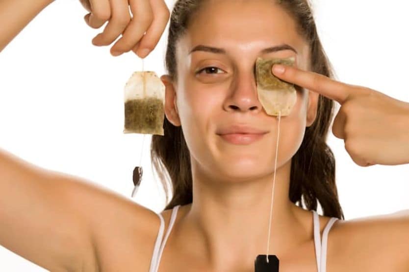 Woman using tea bags as cool compresses for her eyes