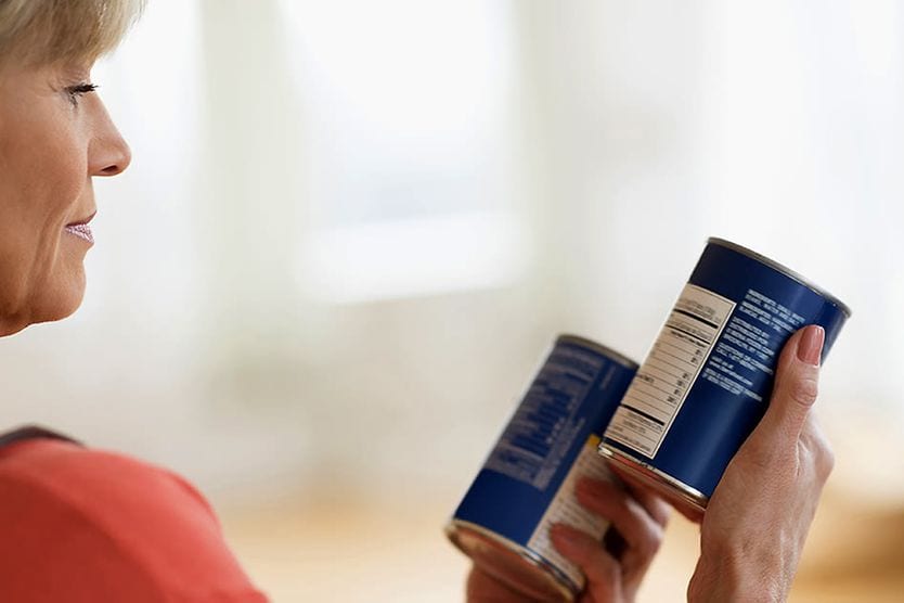 middle-age woman reading can labels without glasses