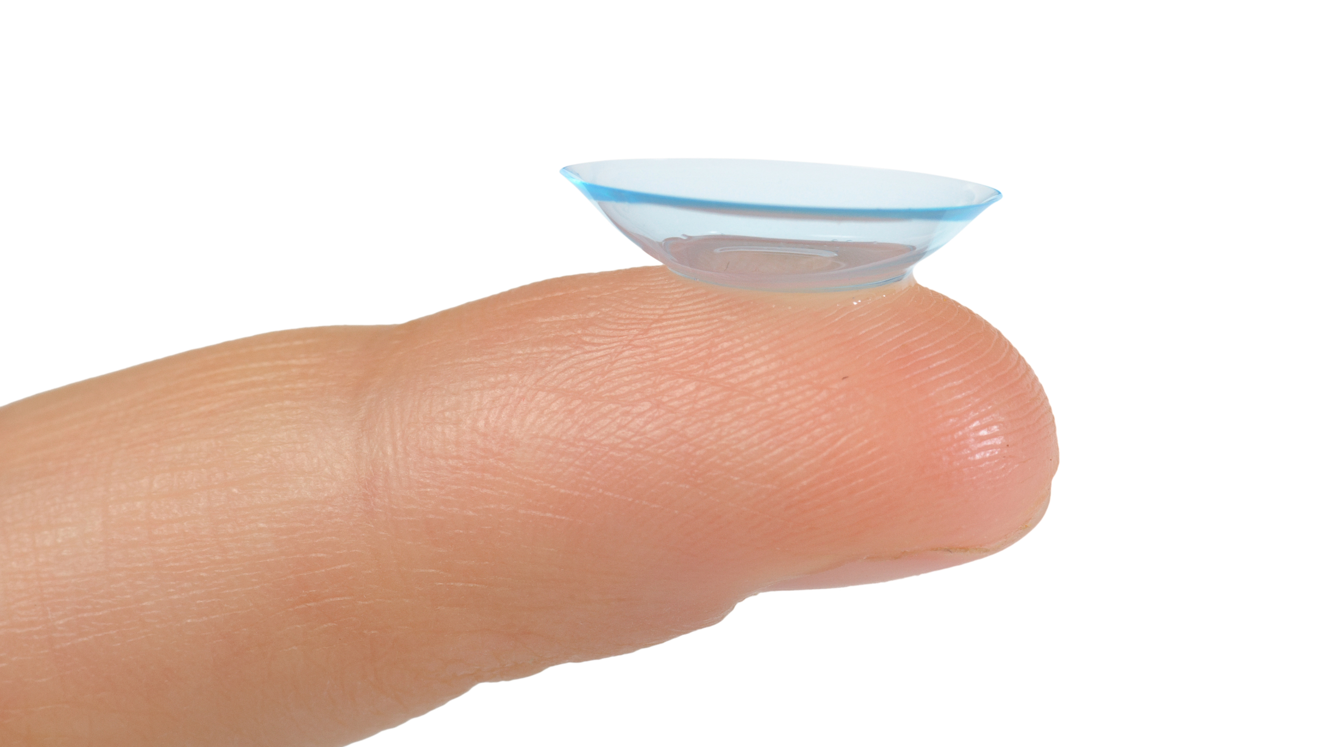 An image of an inside out contact lens, with the edges flipped out, balanced on a fingertip.