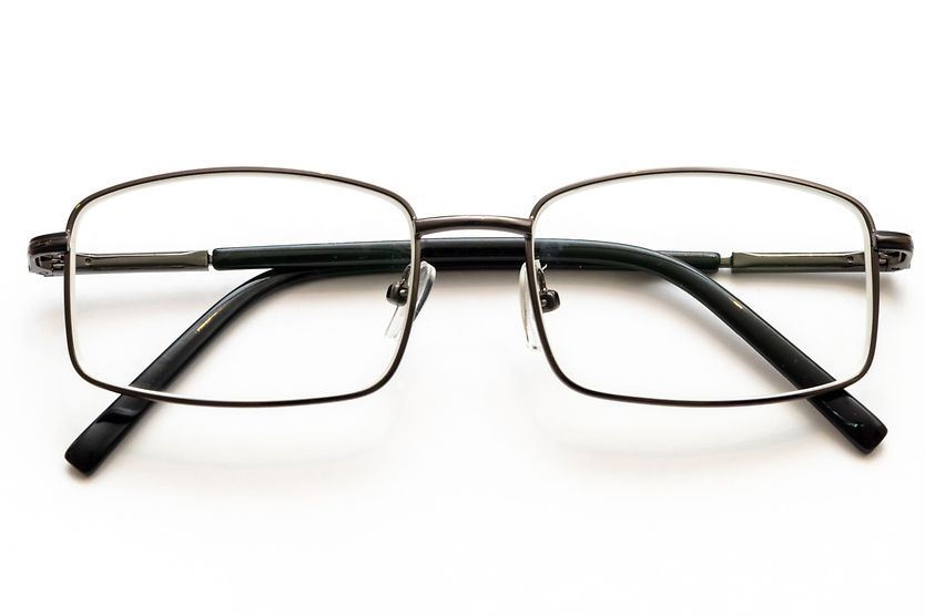 durable men's eyeglass frames placed on top of a black top