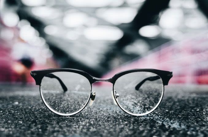 durable men's eyeglass frames placed on top of a black top