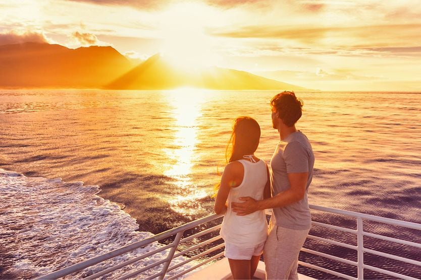 Couple standing AFT on a yacht, looking at the water. Couple standing AFT on a yacht, looking at the water.