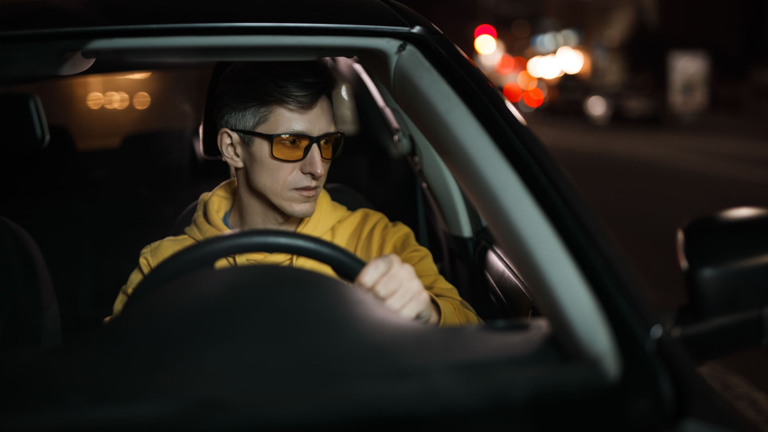 Man wearing night driving glasses while driving Man wearing night driving glasses while driving