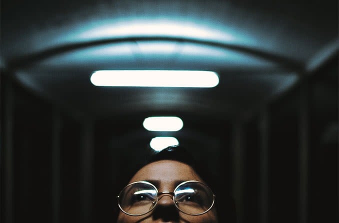 woman wearing eyeglasses looking up at lights