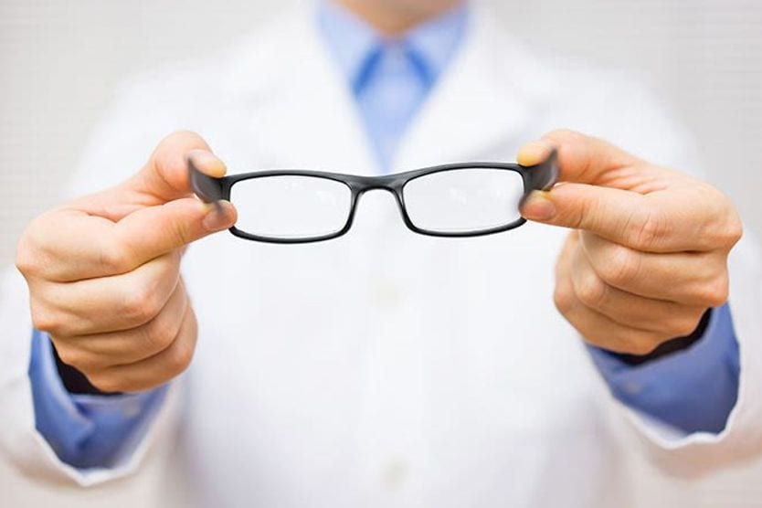 optometrist giving new eyeglasses optometrist giving new eyeglasses