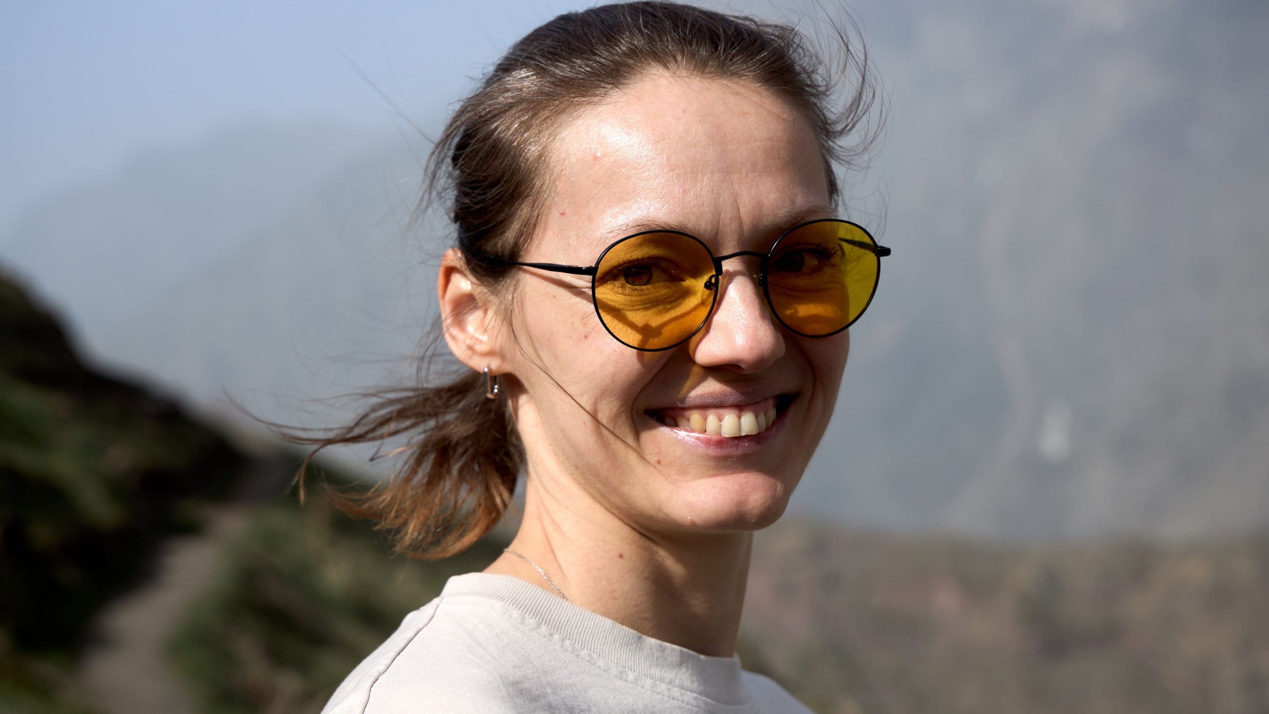 woman wearing yellow tinted sunglasses to protect her eyes from blue light 