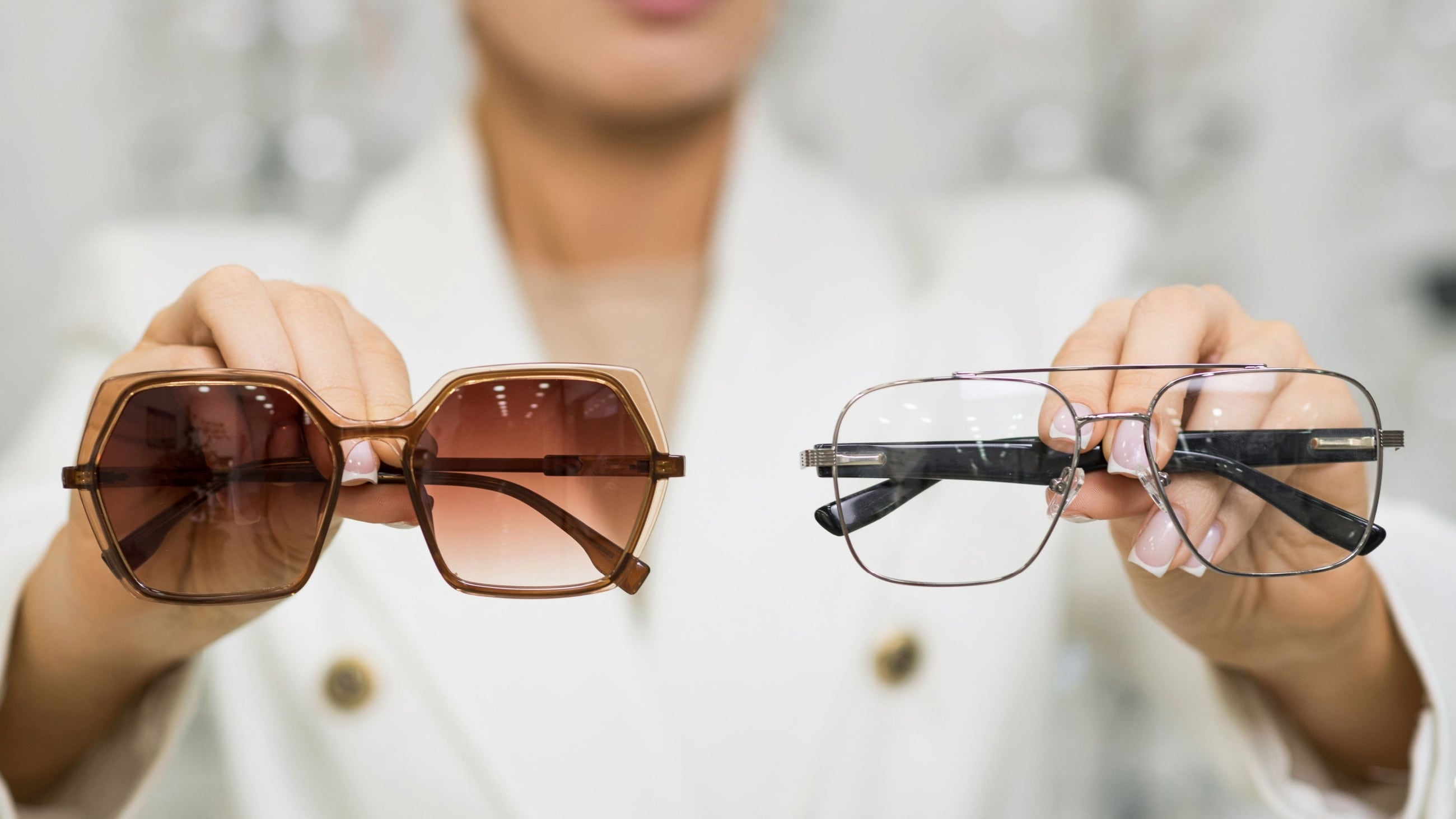 woman holding sunglasses and glasses in hands
