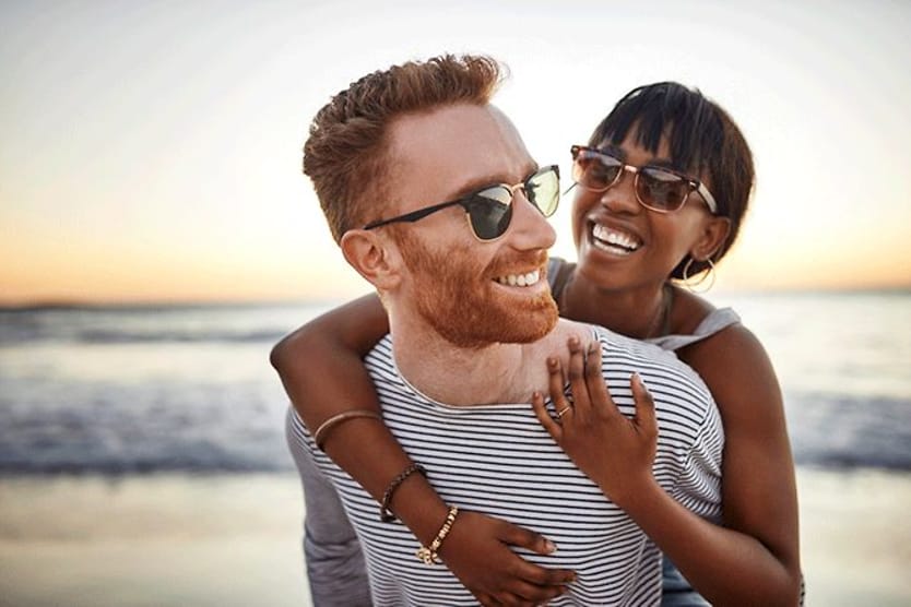 man and woman on beach wearing sunglasses man and woman on beach wearing sunglasses