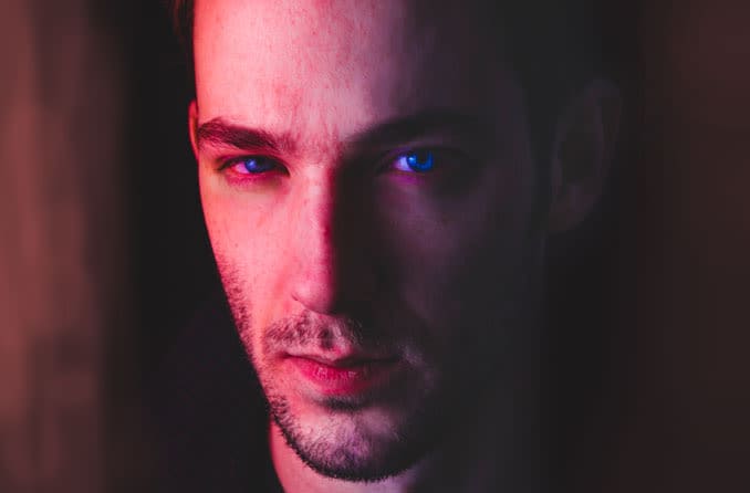 A hand holds a magnifying glass over the words &amp;quot;blurred vision,&amp;quot; which are above a background of many other symptoms of diabetes