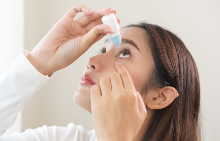 woman putting in eye drops