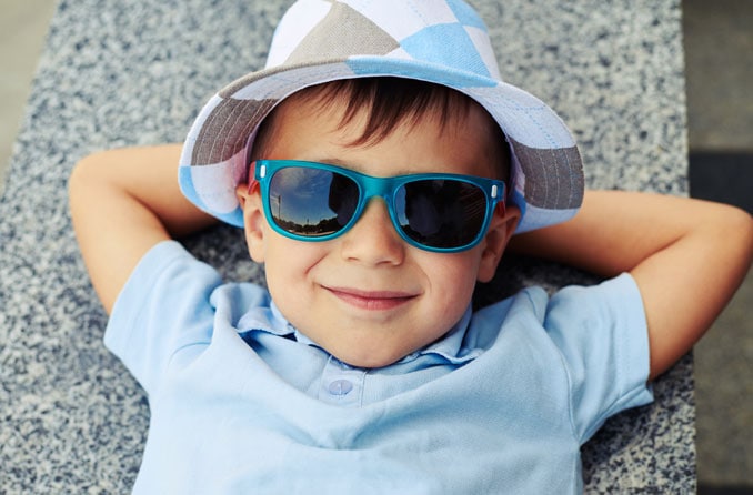 Niño con gafas de sol y sonriente Niño con gafas de sol y sonriente
