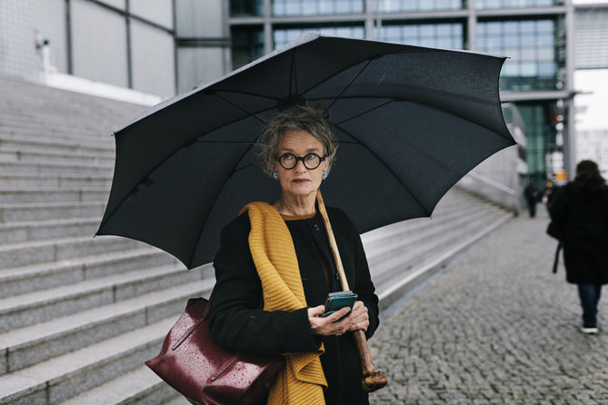 personne à la mode se tenant sous un parasol