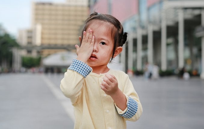 Enfant couvrant les yeux à cause de l'amblyopie