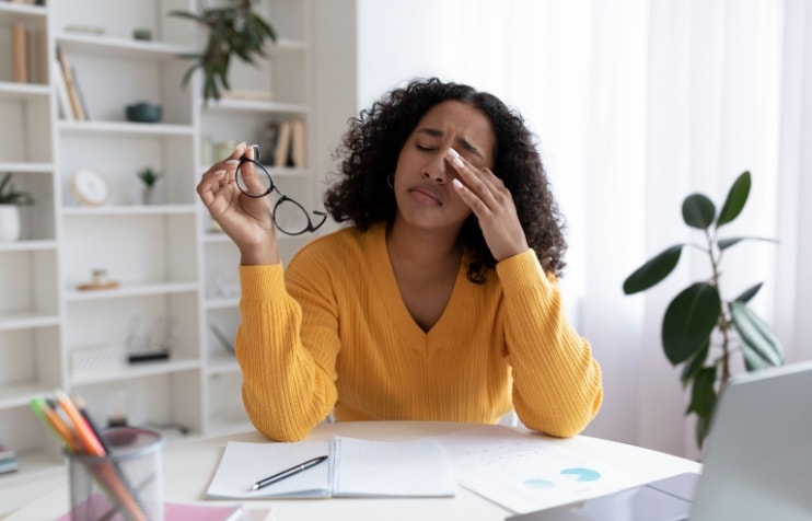 Woman rubbing eyes.