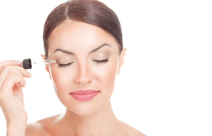 Woman using eyelash serum