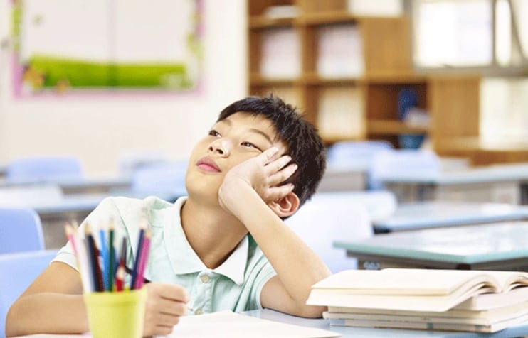 Un ragazzino a scuola guarda in lontananza