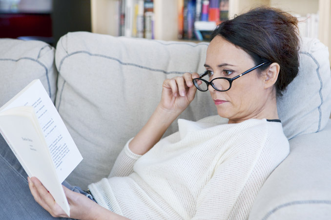 Donna con occhiali da vista che legge un libro