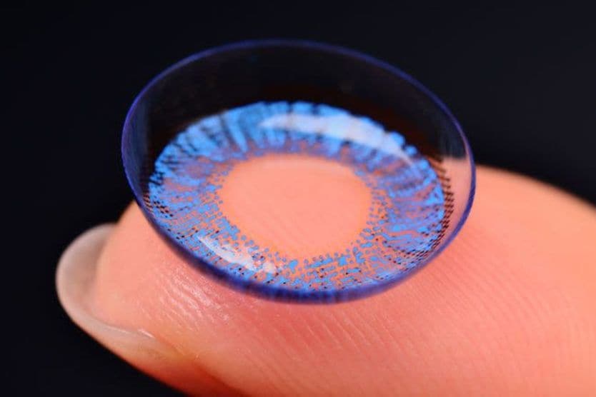 Woman placing contact lens on eye