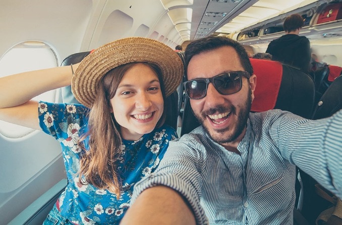 Giovane coppia che si fa un selfie su un aereo Giovane coppia che si fa un selfie su un aereo