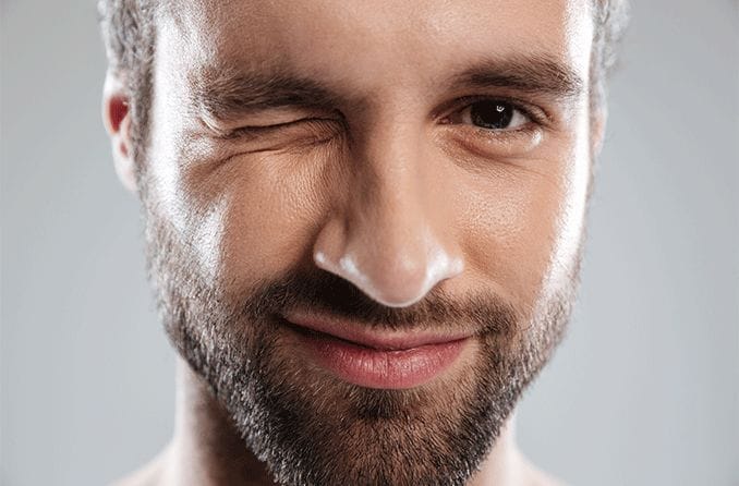 एक आँख बंद करके आँखें सिकोड़ता हुआ आदमी एक आँख बंद करके आँखें सिकोड़ता हुआ आदमी