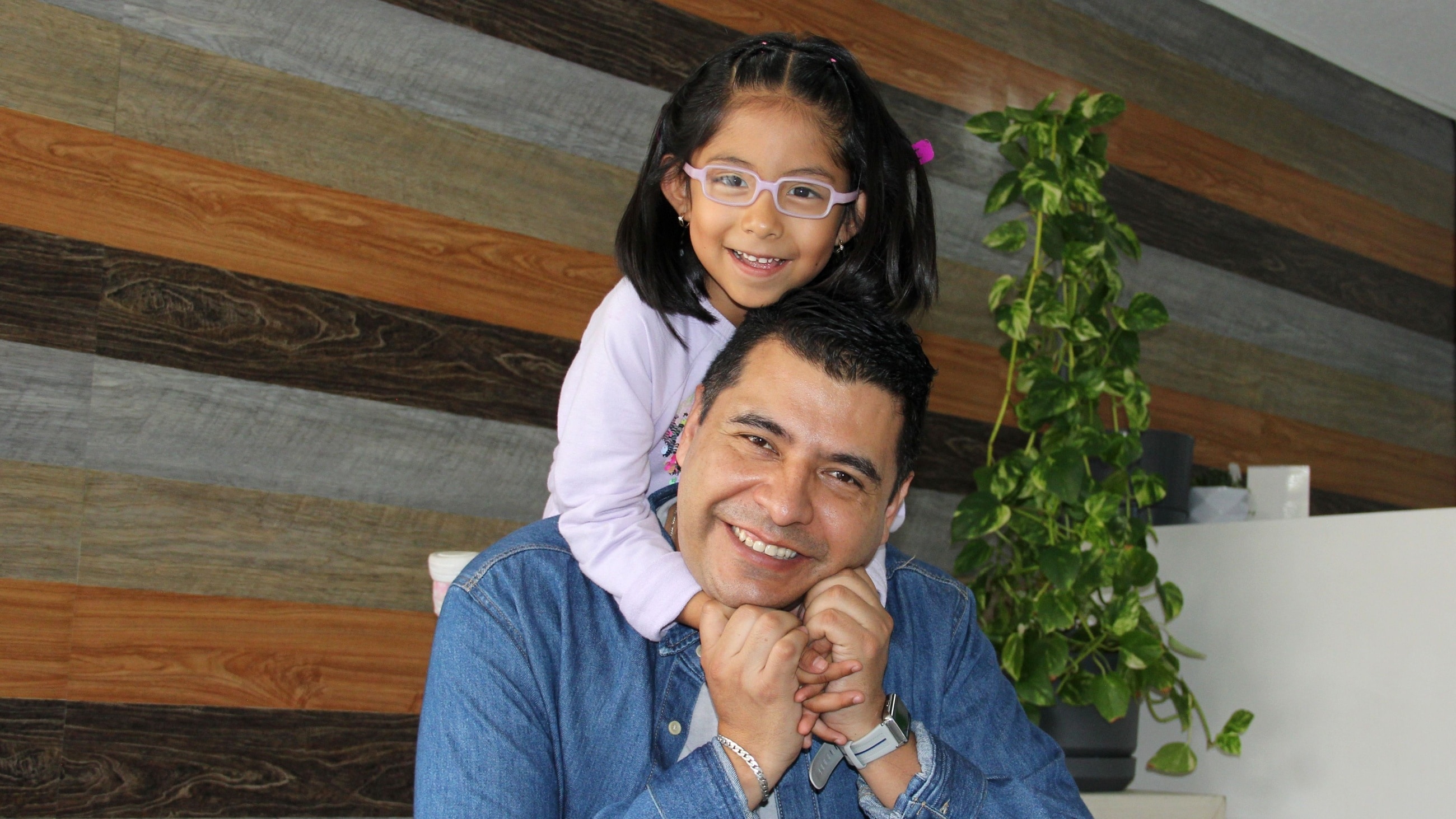 young girl wearing glasses hugging her father young girl wearing glasses hugging her father
