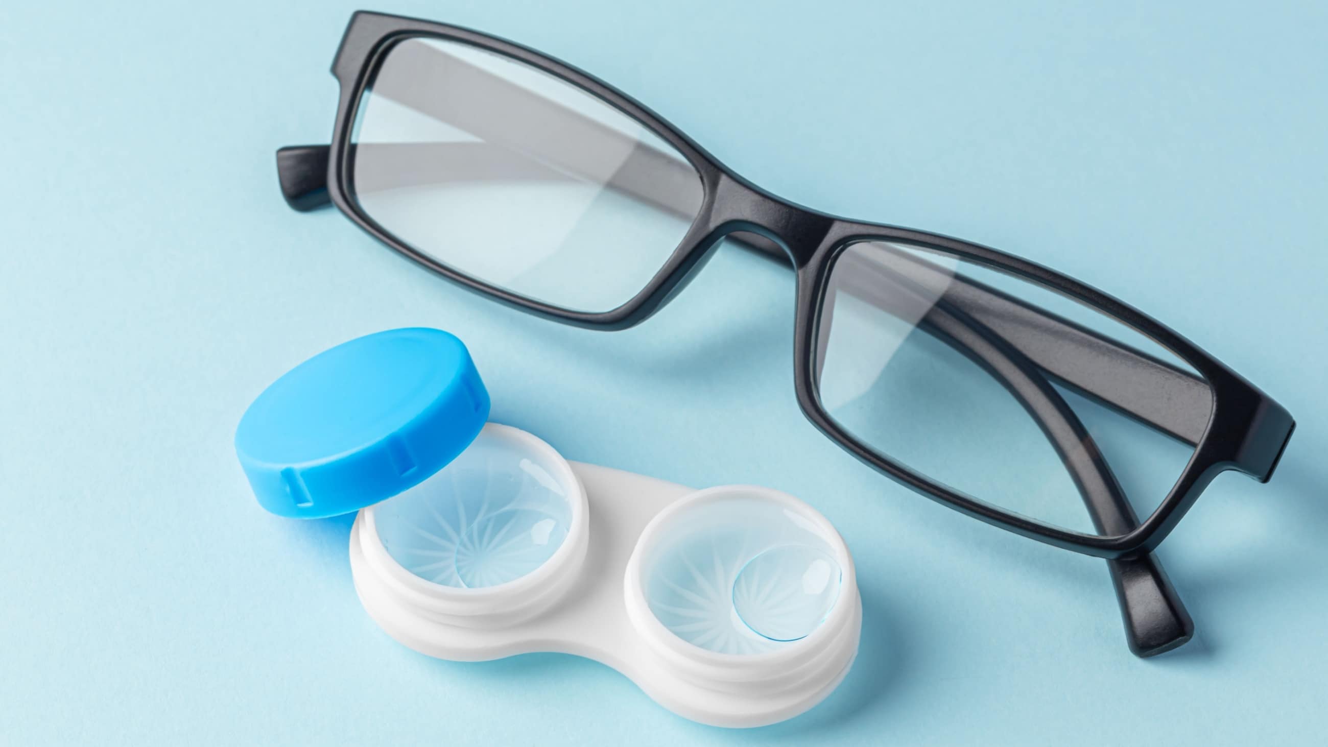 Contact lenses next to glasses