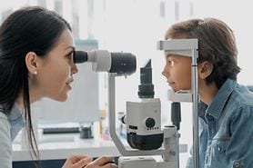A little boy has his eyes examined by a pediatric optometrist.