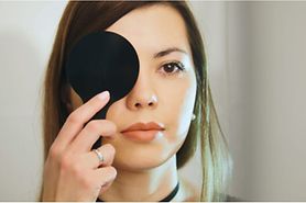 woman covering her eye during eye test