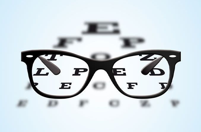 Eyeglasses with black frames positioned on an ophthalmic eye test table