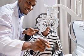 woman getting an eye exam where doctor uses phoropter