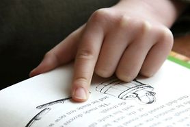 Child reading with their finger