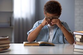 boy rubbing his eyes