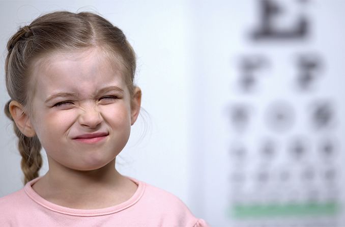 child squinting at eye chart child squinting at eye chart