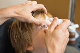 child getting atropine eye drops put into their eyes child getting atropine eye drops put into their eyes