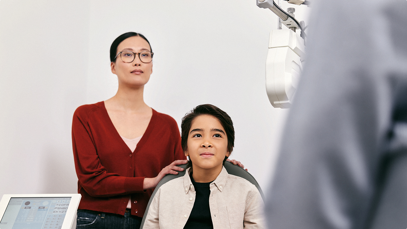 A young boy wearing glasses gets help with his homework