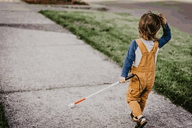 child with high myopia using walking stick who has a rare condition