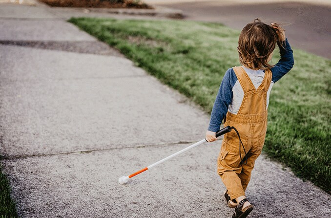 child with high myopia using walking stick who has a rare condition