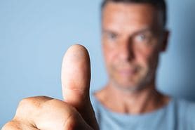 man holding thumb out focusing on astigmatism eye exercises