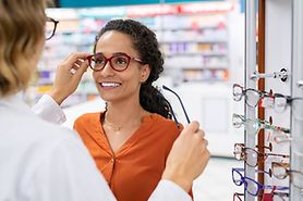 woman trying on eyeglasses to treat her astigmatism