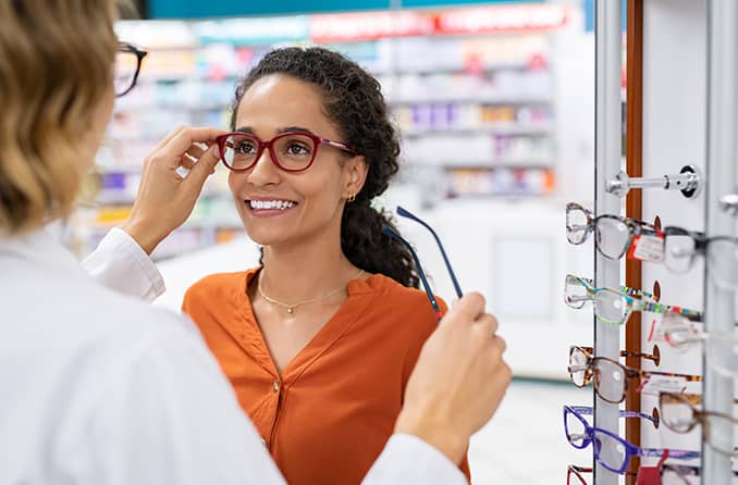 woman trying on eyeglasses to treat her astigmatism woman trying on eyeglasses to treat her astigmatism